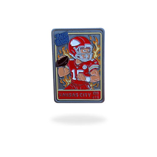 Enamel golf ball marker designed like a vintage trading card, featuring a cartoon quarterback in a red and yellow Kansas City uniform with a helmet and football in hand. Fiery background with bold “Rated Rookie” text, combining football and golf themes in a collectible design.