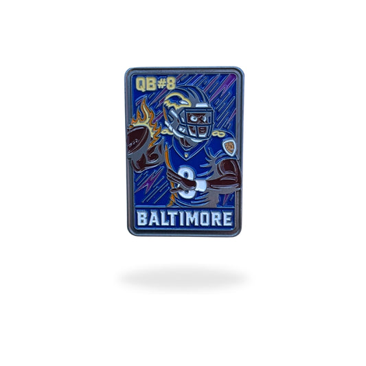 Enamel ball marker styled like a retro football trading card, featuring a cartoon quarterback in a purple and black Baltimore uniform with flames in the background. “Rated Rookie” text is displayed at the top, blending football iconography with collectible golf accessory design.