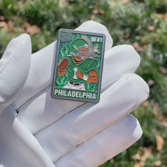 Philadelphia QB #1 ball marker featuring a cartoon football player in midnight-green uniform with flames and eagle-inspired detail – collectible enamel golf ball marker by Pin Creatures.